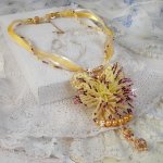 Pendentif La Petite Robe Jaune monté avec des rocailles de qualité couleur Jaune, Cerise et Rose, à laquelle s’ajoute des perles rondes nacrées en Cristal, perles et fleurs en plaqué Or